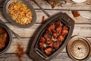 Variety of Indian curry food with tandoori chicken and basmati rice.