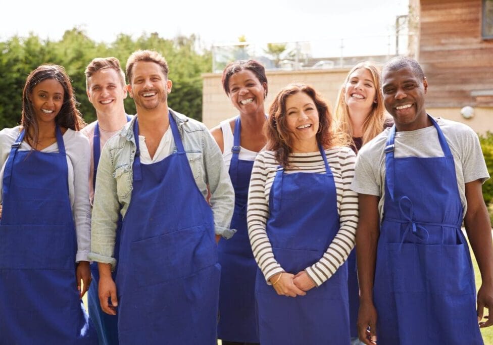 Group Portrait Of Men And Women Attending Cookery Class Relaxing Outdoors