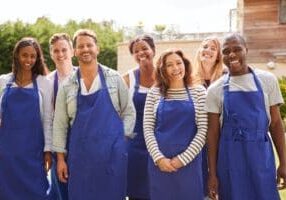 Group Portrait Of Men And Women Attending Cookery Class Relaxing Outdoors