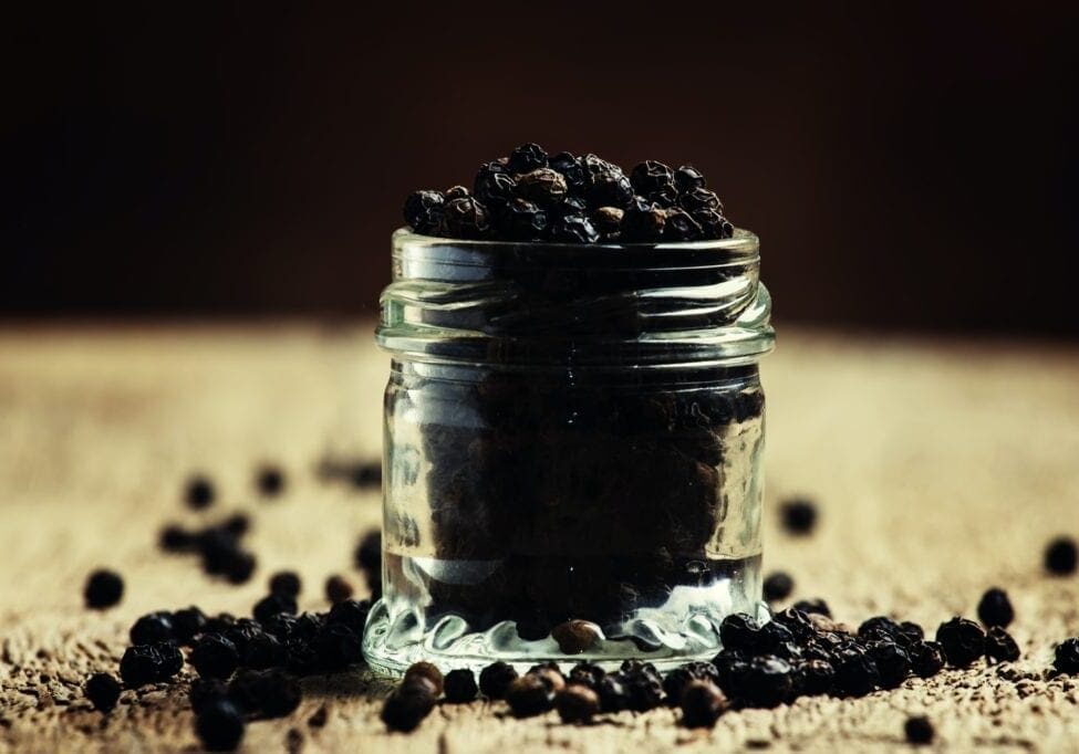 Pea of black pepper in a glass jar